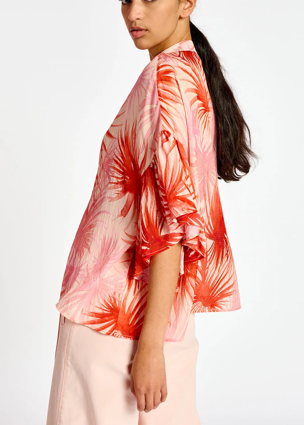 Orange ruffle-detailed top with palm leaf print