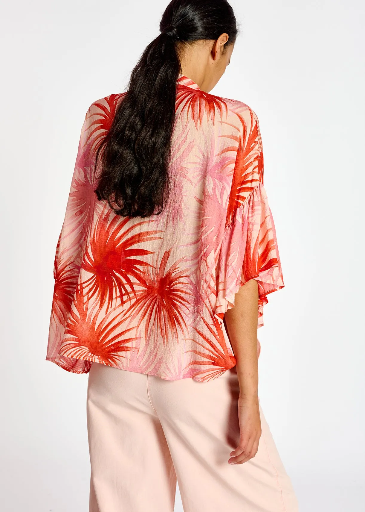 Orange ruffle-detailed top with palm leaf print